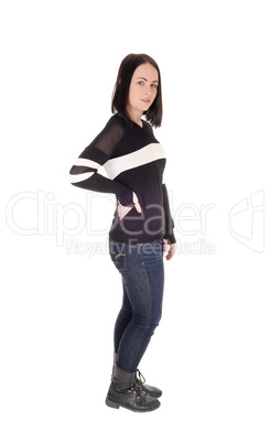 Pretty young woman standing in jeans in profile