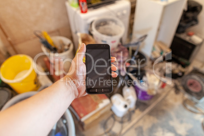 Hand holds a mobile phone on a construction side