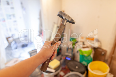 Hand holds a hammer on construction side