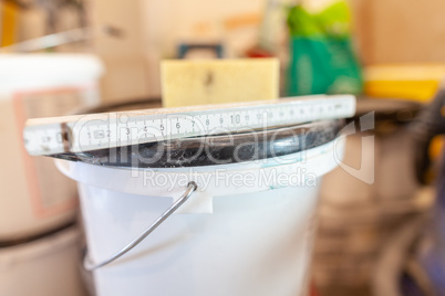 Double meter stick lies on a white bucket