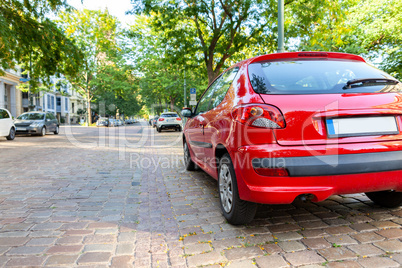 A red car stands on a street