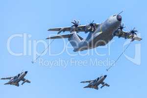 Military Airbus A 400 M transport plane flies with two Panavia Tornado  multirole combat aircrafts at airfield