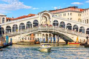 The Rialto Bridge of Venice with gondolas, vaporetto and boats u