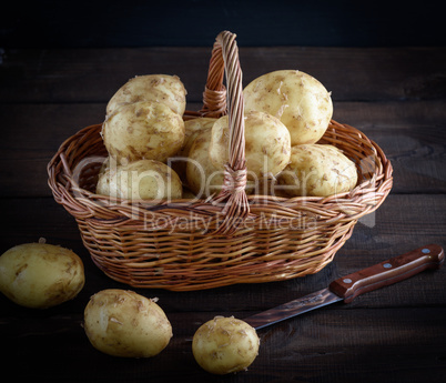 fresh potatoes in a peel lay in a brown wicker basket