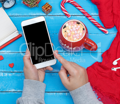 female hands holding white smart phone with blank black screen