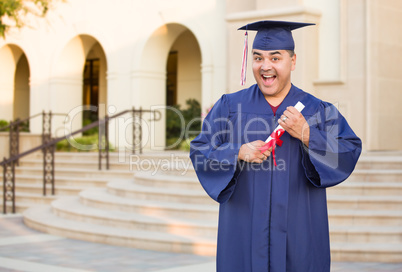 Hispanic Male With Deploma Wearing Graduation Cap and Gown On Campus