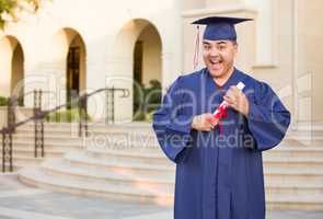 Hispanic Male With Deploma Wearing Graduation Cap and Gown On Campus