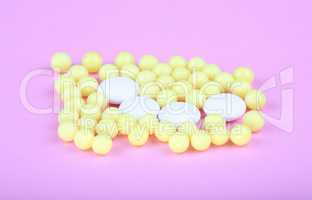 yellow vitamins on pink background