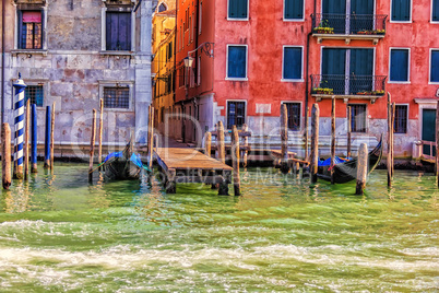 Gondolas moored near a typical narrow street of Venice, Italy