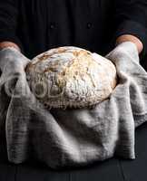 baked round homemade bread on a gray napkin