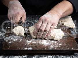 chef cuts white wheat flour dough into pieces