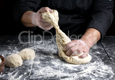 chef kneads dough made of white wheat flour