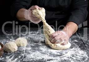 chef kneads dough made of white wheat flour