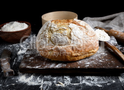 baked round white wheat bread on a brown wooden board