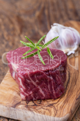 rohes Steak auf dunklem Holz