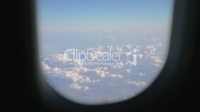 View to the clouds and land from flying airplane