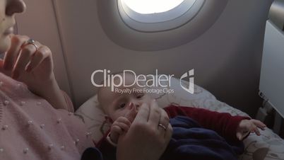 Mother playing with baby daughter in plane
