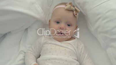 Smiling blue-eyed baby girl with bow