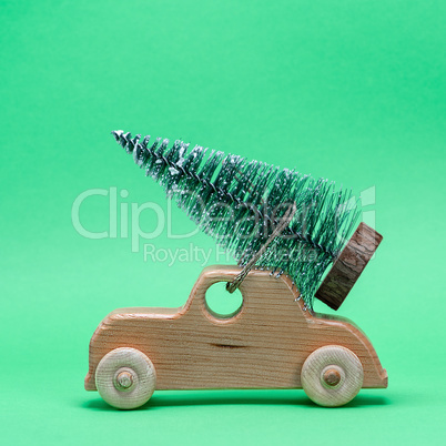 wooden toy car carrying a festive tree on the roof