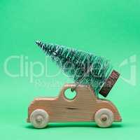 wooden toy car carrying a festive tree on the roof