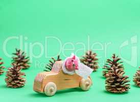 wooden children's car in the midst of cones on a green backgroun