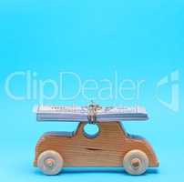 wooden children's car carries on the top of the roof a stack of