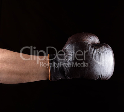 man's hand is wearing a brown leather boxing glove