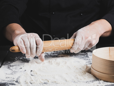 wooden rolling pin in men's hands