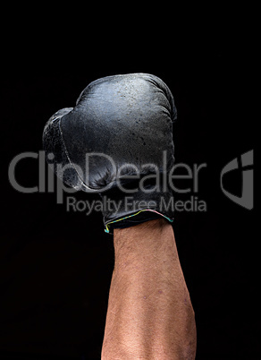 human hand in black leather boxing glove raised up