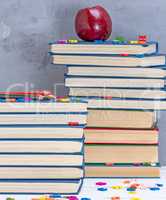 stack of books in the blue cover, multicolored wooden pencils