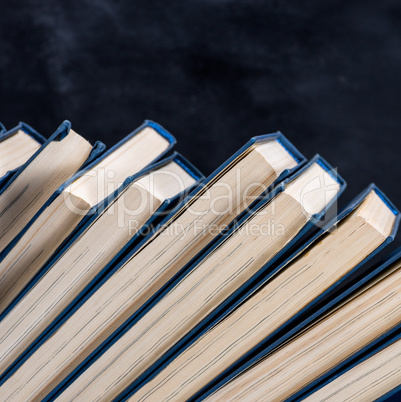 uneven row of books with a blue cover