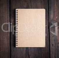 notebook on a black iron spring with brown empty sheets