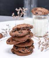 stack of round chocolate cookies and milk