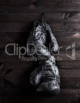 black leather boxing gloves hanging on a nail