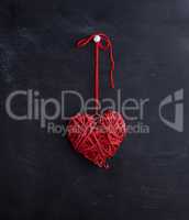 small wicker red heart hangs on a rope