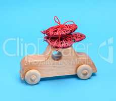 small wooden children's car carries a wicker red heart