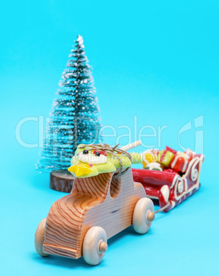 wooden children's car carries a caramel holiday spruce and pulls