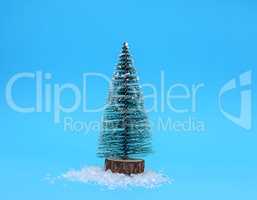 miniature artificial Christmas tree on a blue background close u
