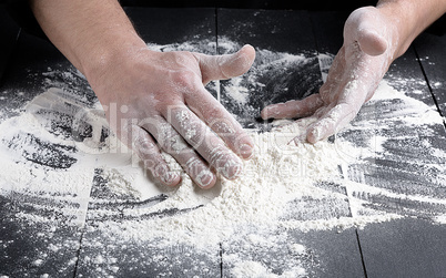 white wheat flour on a black wooden table