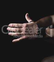 man wraps his hands in black textile bandage
