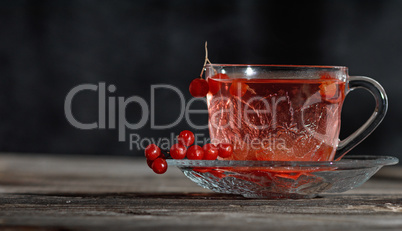 hot viburnum tea in a transparent cup with a handle