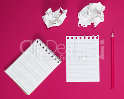 notebook with white sheets and a crumpled ripped out sheet of pa