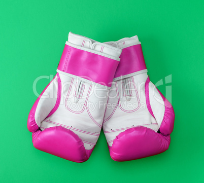 pair of pink-white leather boxing gloves on a green background