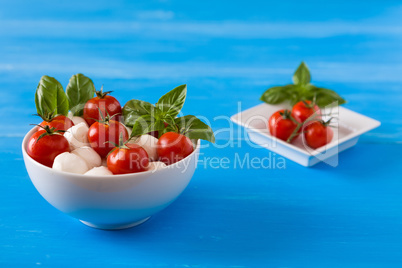 Mozzarella, cherry tomatoes and basil in a bowl