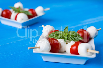 Closeup of skewers with mozzarella, cherry tomatoes and basil