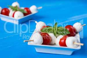 Closeup of skewers with mozzarella, cherry tomatoes and basil