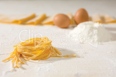 Closeup of fresh uncooked tagliatelle pasta over a table