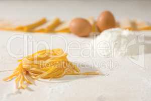 Closeup of fresh uncooked tagliatelle pasta over a table