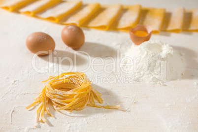 Fresh uncooked tagliatelle pasta over a table