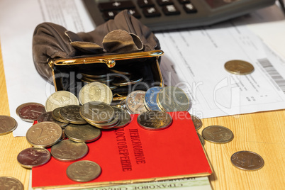 Bill for payment, points, wallet with coins and calculator on the table surface. Translation of the inscription: "pensioner's Certificate"